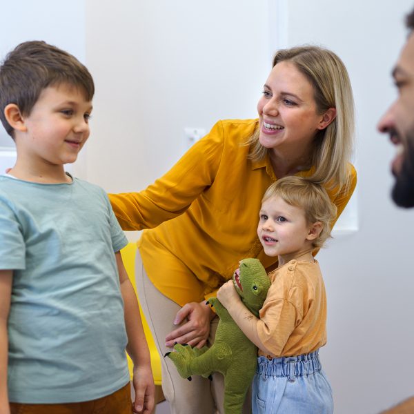 Young multiracial dentist playing with kids at his office in dentist clinic.